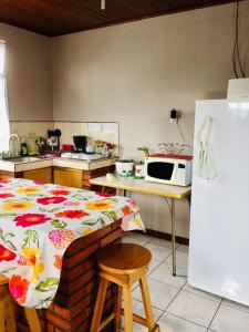 a kitchen with a bed and a microwave and a refrigerator at Casa Bambú Tropical in Alajuela