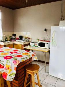 a kitchen with a bed and a microwave and a refrigerator at Casa Bambú Tropical in Alajuela City