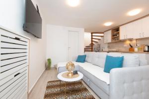 ein weißes Wohnzimmer mit einem weißen Sofa und blauen Kissen in der Unterkunft Casa del Mare Bjelila in Tivat