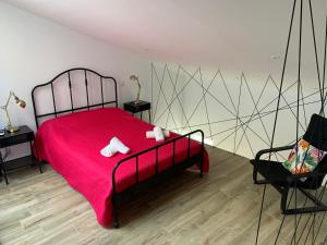 um quarto com uma cama com um cobertor vermelho e uma cadeira em CASA DAS CEGONHAS em Faro