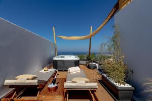 Un balcón con 2 camas y una hamaca. en Divino Suites en Fira