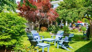 a group of blue chairs and a table in a yard at The Village Motel in Naramata