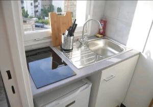 a small kitchen with a sink and a window at Super studio proche de Paris Porte de Versailles ! in Vanves