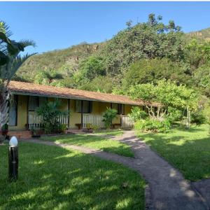 a house with a mountain in the background at Pousada Embaubas in Serra do Cipo