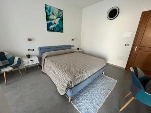 1 dormitorio con 1 cama, mesa y sillas en Baboe Affittacamere IUN F1037, en Torre Grande