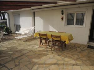 a yellow table and chairs on a patio at La maison du Barbot Maison 6 couchages in Gujan-Mestras
