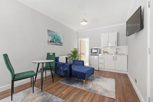 a living room with a blue couch and a table at Stunning studio flat with free on-street parking! in Plumstead