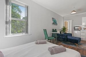 1 dormitorio con 1 cama, mesa y sillas en Stunning studio flat with free on-street parking!, en Plumstead