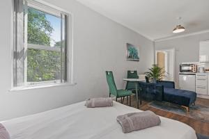 a bedroom with a bed and a table and chairs at Stunning studio flat with free on-street parking! in Plumstead