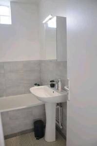 a bathroom with a sink and a tub and a mirror at Super studio proche de Paris Porte de Versailles ! in Vanves