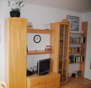 a room with two wooden book shelves and a television at Iderhoff Iderhoff 19 in Norderney