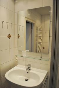 a white bathroom with a sink and a mirror at Iderhoff Iderhoff 19 in Norderney