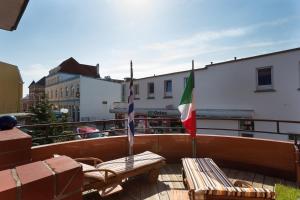 d'un balcon avec deux bancs et un drapeau. dans l'établissement Amici JBST 4 Whg Amici, à Norderney 3 autres photos