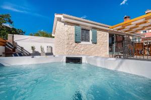 a swimming pool in front of a house at HACIENDA GASPAROVIC in Sukošan