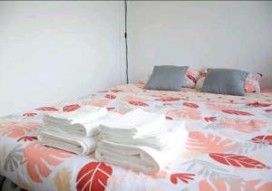 a bed with towels stacked on top of it at Super studio proche de Paris Porte de Versailles ! in Vanves