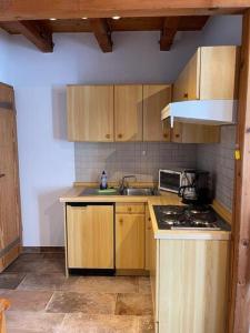 a kitchen with wooden cabinets and a sink and a stove at Kleines Friesenhaus Kleines Friesenhaus in Norderney