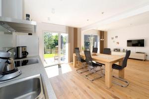 a kitchen and dining room with a wooden table and chairs at Traum vom Meer Traum vom Meer 2 in Norderney