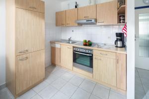 eine Küche mit Holzschränken und einer Spüle in der Unterkunft Iderhoff Iderhoff 45 in Norderney