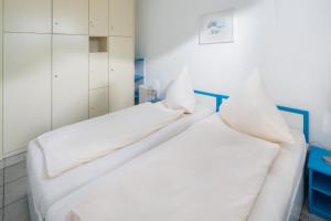 two beds in a room with white walls at Iderhoff Iderhoff 45 in Norderney