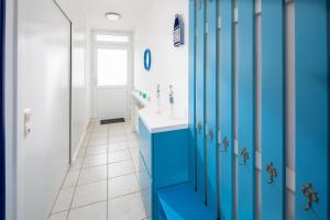 a blue bathroom with a sink and a mirror at Iderhoff Iderhoff 45 in Norderney