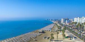 a view of a beach with umbrellas and the ocean at HAVEN HOUSE in Larnaca