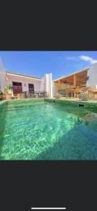 una gran piscina de agua frente a un edificio en Riad Dada Mouss & Suites, en Marrakech