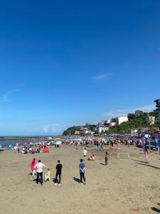 a large group of people on a beach at sunset villa in Cimenli