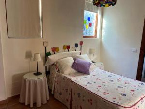 a bedroom with a bed and two tables with flowers on it at VILLA CANTARES in Málaga