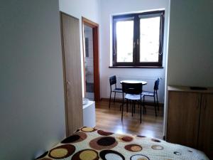 1 dormitorio con cama, mesa y ventana en Piernikowy Dworek, en Lubicz