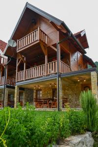 a large wooden house with a large balcony at Vikendica pored Drine in Bajina Bašta