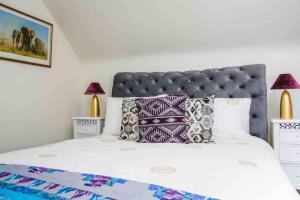 a bedroom with a large bed with pillows on it at Kingfisher Riverside Retreat in Kenmare
