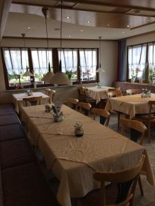 a dining room with tables and chairs and windows at Gasthof Richebächli in Elzach