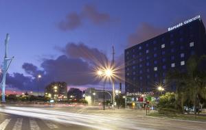 een stadsstraat 's nachts met een gebouw en straatverlichting bij Barceló Valencia in Valencia