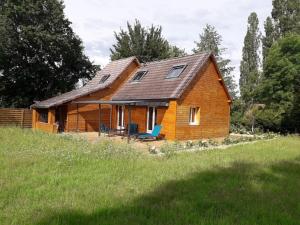une maison en bois avec deux chaises dans un champ dans l'établissement Lodge avec SPA pour 6 pers, proche de Guédelon, à Tannerre-en-Puisaye