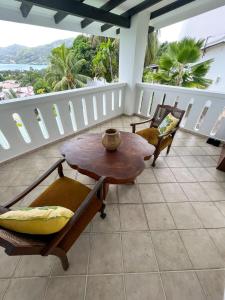 un patio con tavolo e sedie sul balcone. di Bottle Palm Villa a Victoria