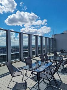 Un balcón con mesas y sillas en un edificio en JBHotels Apartament Comfort Hanza Tower, en Szczecin