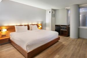 a bedroom with a large white bed and a window at Truss Hotel Times Square in New York