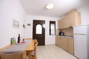 a kitchen with a dining table and a kitchen with a refrigerator at MaGia Peristeridi in Polychrono +39 photos