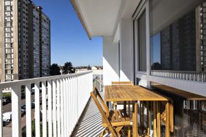 un balcone con tavolo e sedie in legno su un edificio di LE COOL LEVEL a Chalon-sur-Saône