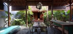 un patio con mesa y sillas en una casa en Klotok Surf Shack, en Klungkung