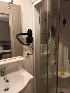 a bathroom with a shower and a sink and a mirror at PENSION LA PARADA in Fabero