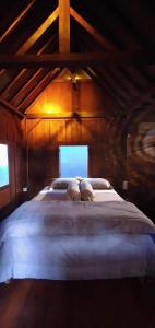 1 dormitorio con 1 cama grande en el ático en Klotok Surf Shack, en Klungkung