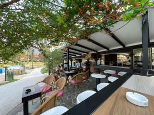 a restaurant with tables and chairs and trees at Apartments Park 2016 in Surdulica