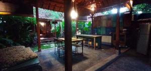 a patio of a house with a table and chairs at Klotok Surf Shack in Klungkung