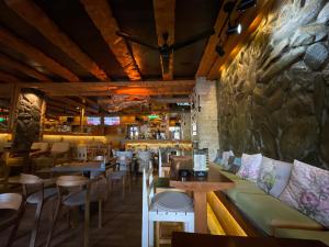 a restaurant with tables and chairs and a stone wall at Apartments Park 2016 in Surdulica