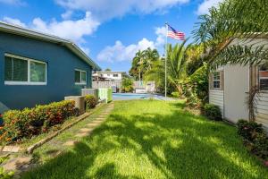 einen Hof mit amerikanischer Flagge vor einem Haus in der Unterkunft Trendy 3-bedroom villa with saltwater pool and yard in Fort Lauderdale