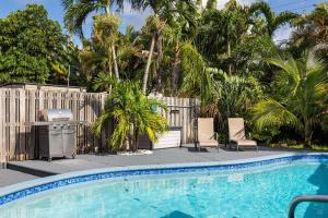 einen Pool mit Stühlen neben einem Zaun in der Unterkunft Trendy 3-bedroom villa with saltwater pool and yard in Fort Lauderdale