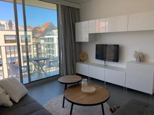 een woonkamer met een bank en een tv bij Vakantie Nieuwpoort Bad in Nieuwpoort