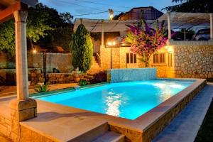una piscina en un patio trasero por la noche en Villa Nada, en Zaton