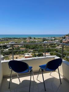 two chairs on a balcony with a view of the ocean at MEGA Apartments in Fushë-Draç